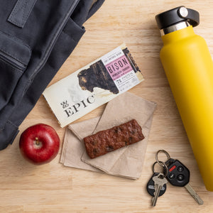 Product on napkin on light wood surface with package, car keys, snack theme